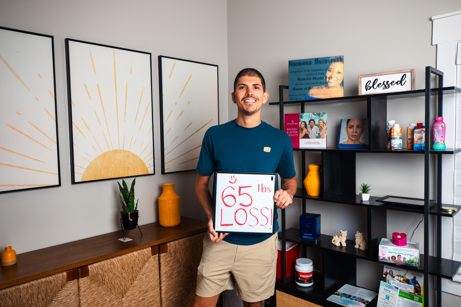 A smiling Cura patient holding a sign that reads 65 pounds lost